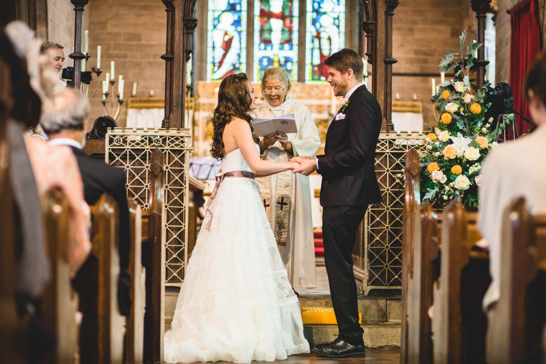 Bride and groom laugh at Eastnor church