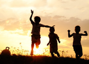 Silhouette,,Group,Of,Happy,Children,Playing,On,Meadow,,Sunset,,Summertime